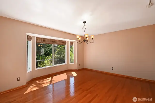 Large dining room bathed in dappled sunlight with a deck out front to appreciate this peaceful setting. Beautiful hardwoods in the main rooms except the living room which is carpeted.