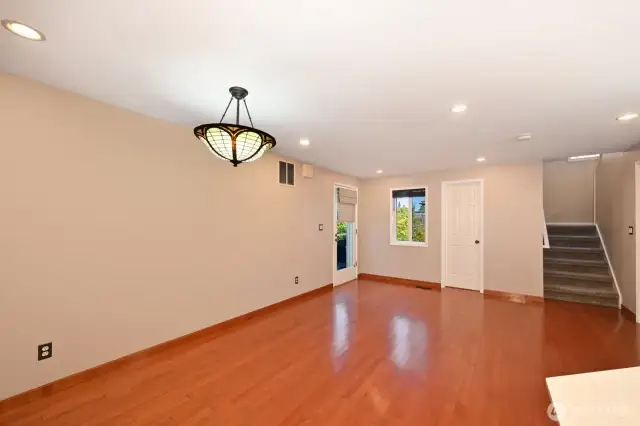 Door to the back patio and yard, half bath behind white door, stairs up to four bedrooms and stairs down to the lower level.
