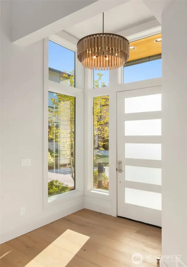 Light filled entry flanked by window walls and accented by designer selected hanging fixture