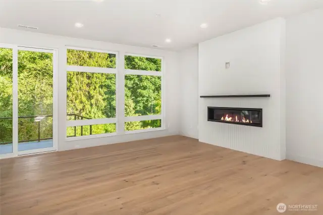 Living space flooded with natural light through floor to ceiling windows and 10 foot ceilings connected to outdoor living on greenbelt backing deck