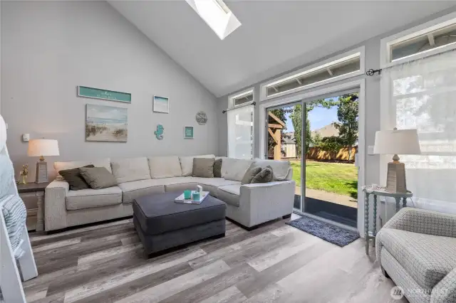 Sunken living room houses vaulted ceilings, skylights,  & patio access!