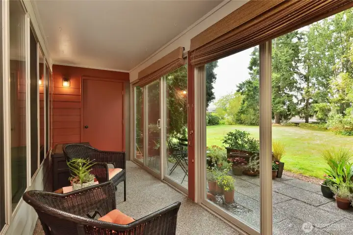 Enclosed porch to a park-like setting.