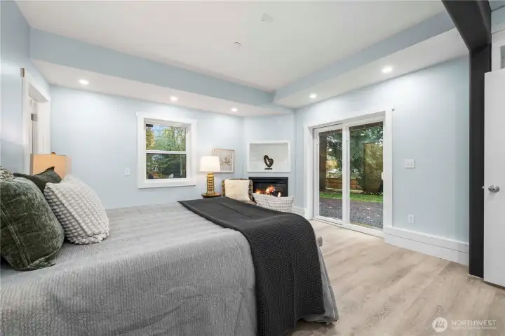 On the lower level, a gorgeous 2nd primary suite awaits, with a gas fireplace and views of sky and trees. The private luxury bath offers both a walk-in shower and separate soaking tub, plus a walk-in closet with shelving built right in. Step out through the slider to the serene back yard – a great spot to add a table and comfy chairs for your morning coffee.