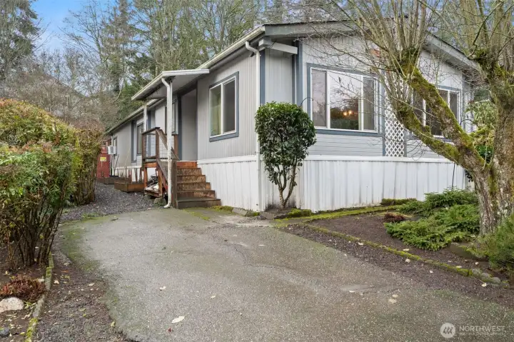 Front exterior of the home with paved driveway , Covered Front porch entry.