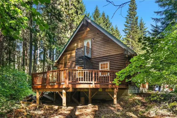 This is the back of the home showing large, entertaining sized deck and beautiful iron staircase leading to upper level