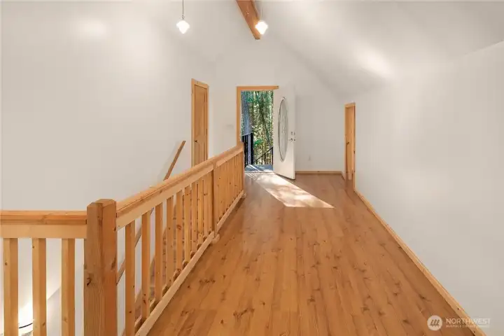 Upstairs master bedroom area with door leading out to stairway to deck below