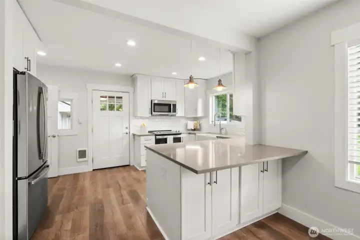 Kitchen with quartz countertops and subway tile.