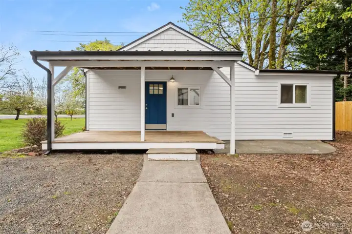 Covered back porch with door leading into the kitchen,
