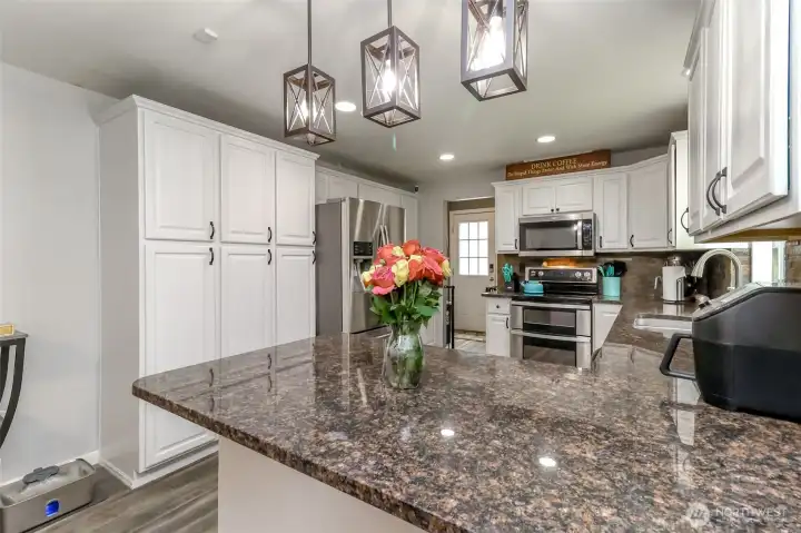 The slab granite counter overhangs so there is roof to put several stools to eat at the counter! Notice the newer pendant light fixtures! The slab granite counter overhangs so there is roof to put several stools to eat at the counter! Notice the newer pendant light fixtures!