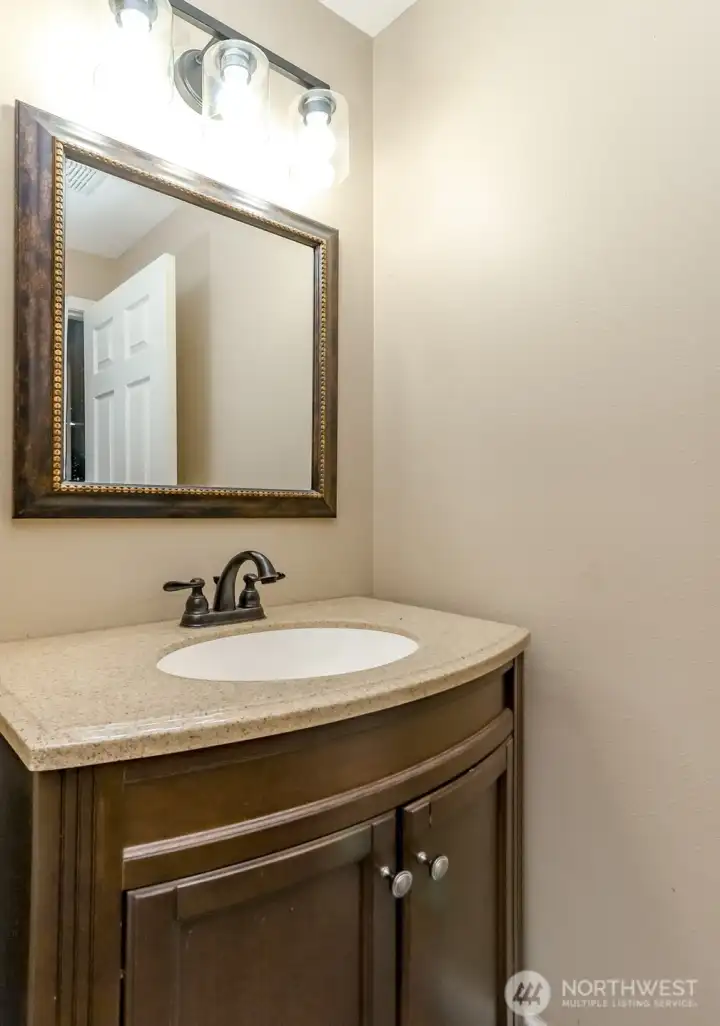 The main floor has an updated 1/2 bath. Notice the newer lighting and cabinetry The main floor has an updated 1/2 bath. Notice the newer lighting and cabinetry