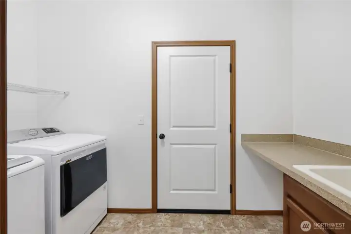Utility room with sink conveniently located off from the garage and the kitchen.