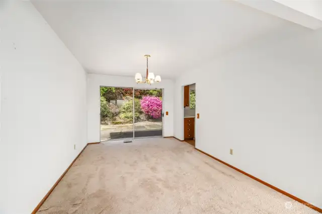 Extra wide sliding glass door leads to rear yard with beautiful mature landscape and large cement patio