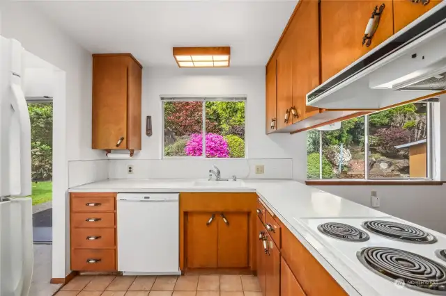 Built in oven, drop in stove, dishwasher, and refrigerator  Window at sink overlooks rear yard  Solid wood cabinets, Formica counters and tile floor
