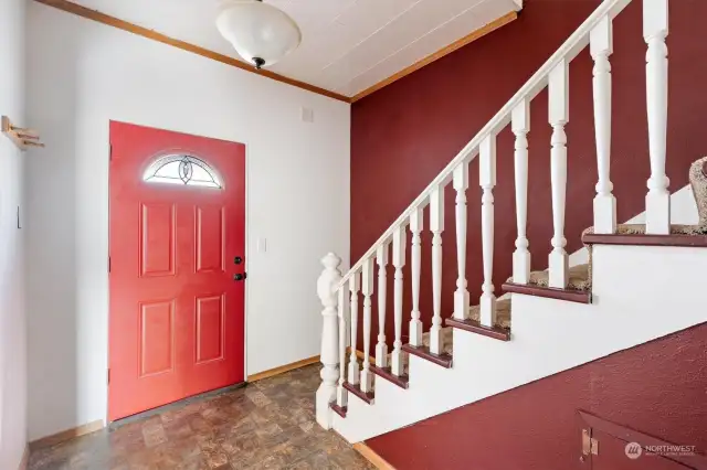 Entryway with under-staircase storage and coat closet.