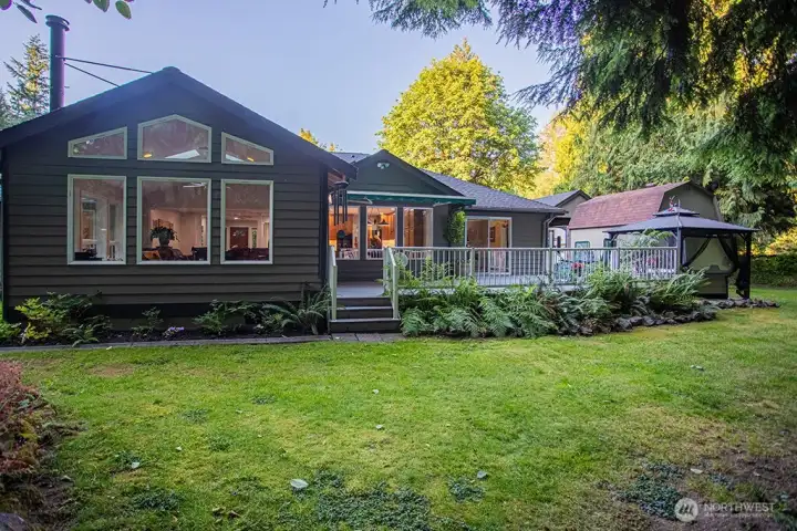 Back of house with deck and hot tub