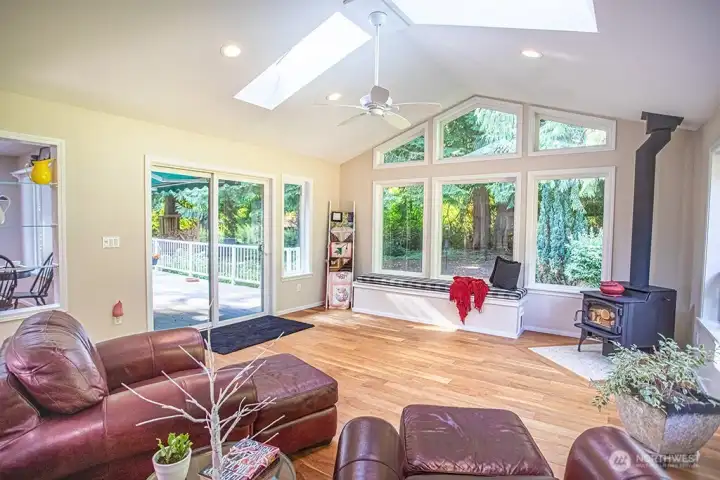 Family room with wood buring stove and seating bench for those guests,walk thru slider and enjoy deck and salt water hot tub