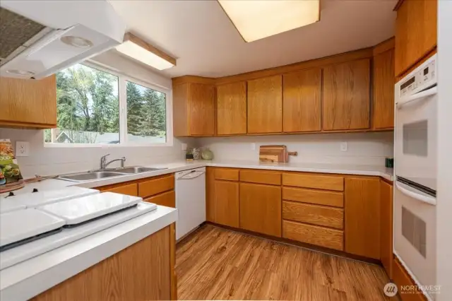 The kitchen is truly the heart of the home—anchored by solid oak cabinets that can easily be refreshed with a modern coat of paint. There’s plenty of room for guests to gather, lend a hand, or simply keep the cook company.