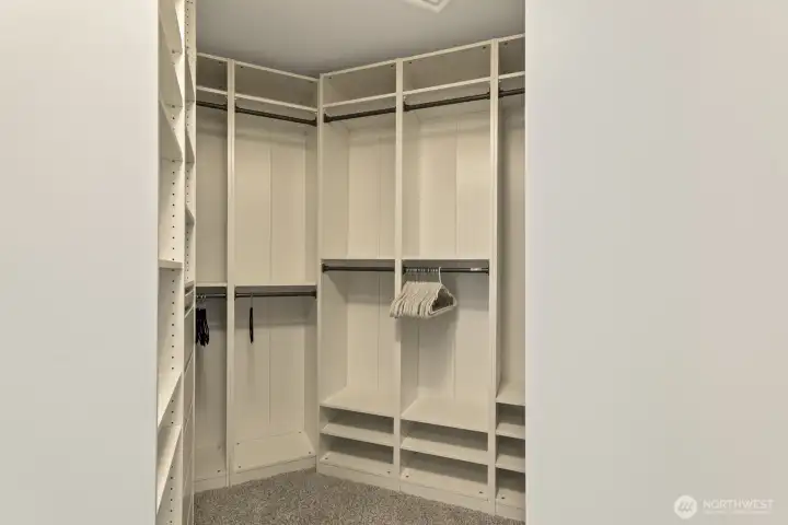 Primary closet with custom built-ins and a hidden laundry chute—come experience this unique detail in person.