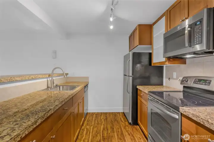 The kitchen has an amazing workspace. Enjoy shaker cabinets, new microwave, glass cooktop and tons of cabinet space. Granite counters and 1 compartment sink.  Tile accents make the space feel modern and clean up is a breeze.