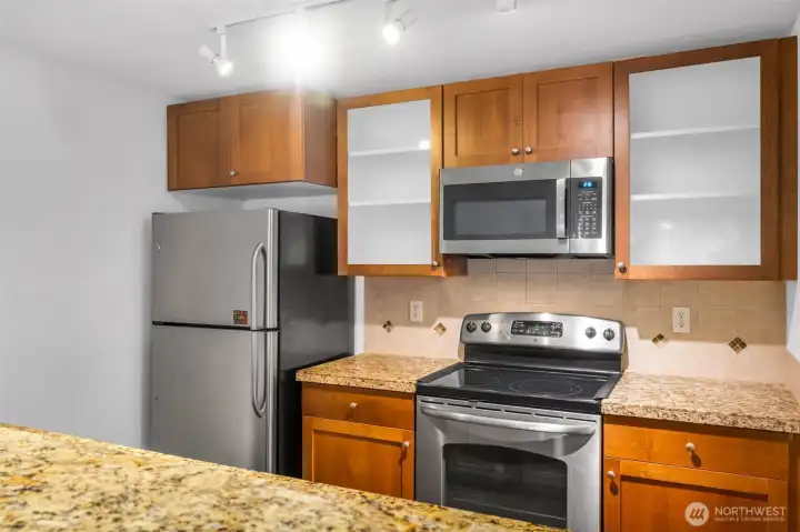 The kitchen has an amazing workspace. Enjoy shaker cabinets, new microwave, glass cooktop and tons of cabinet space. Granite counters and 1 compartment sink.  Tile accents make the space feel modern and clean up is a breeze.