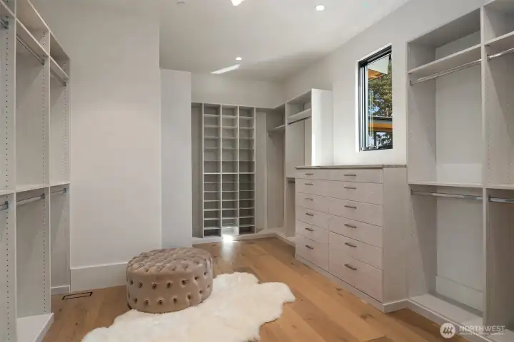 Elegant walk-in closet with custom cabinetry and abundant space for wardrobe and accessories.