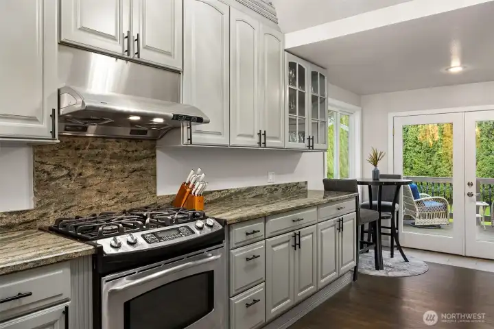 Rich granite countertops and backsplash are both modern and timeless. Room for kitchen eating or coffee/tea space.