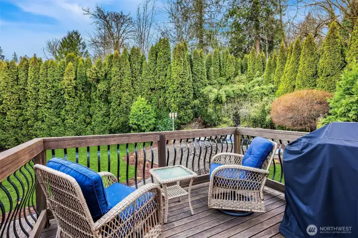 The deck off of the kitchen overlooks the private and lush garden spaces and koi pond.