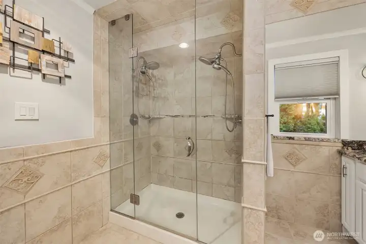 A sumptuous shower with double faucets and full tile surround.