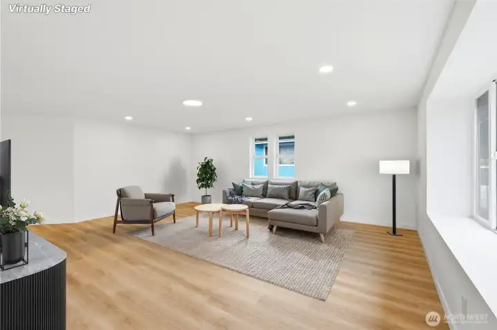 Bright & open living room boasts new luxury vinyl plank flooring, energy-efficient recessed lighting and an expansive bay window.