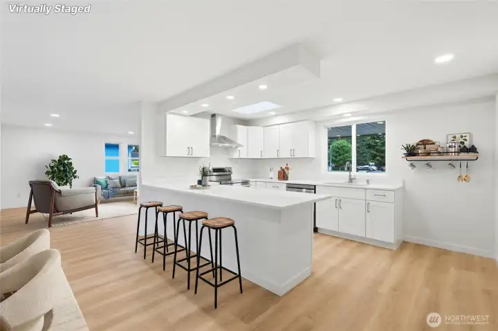 The chef's kitchen shines with new quartz countertops, new fixtures, new cabinetry, new stainless steel appliances, a breakfast bar island, & a large pantry.