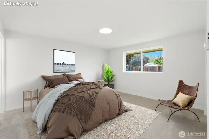 Generous primary bedroom features new carpeting, a private en-suite & a large window overlooking the private backyard.