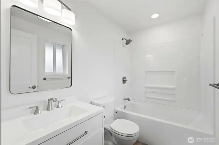 Primary en-suite features new quartz counters & cabinetry, new lighting, & new fixtures.