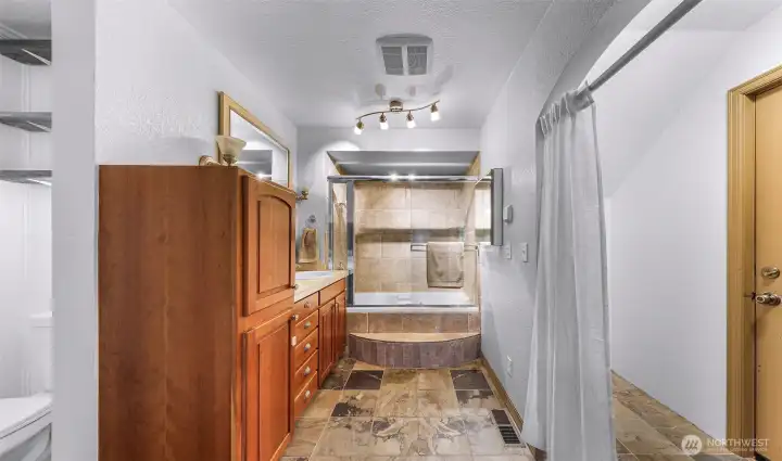 Primary bathroom with dual vanity, soaking tub, and shower.