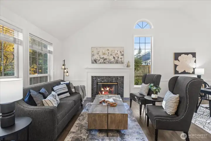 Formal living room with vaulted ceilings, expansive arched windows, and a timeless fireplace define the formal spaces.