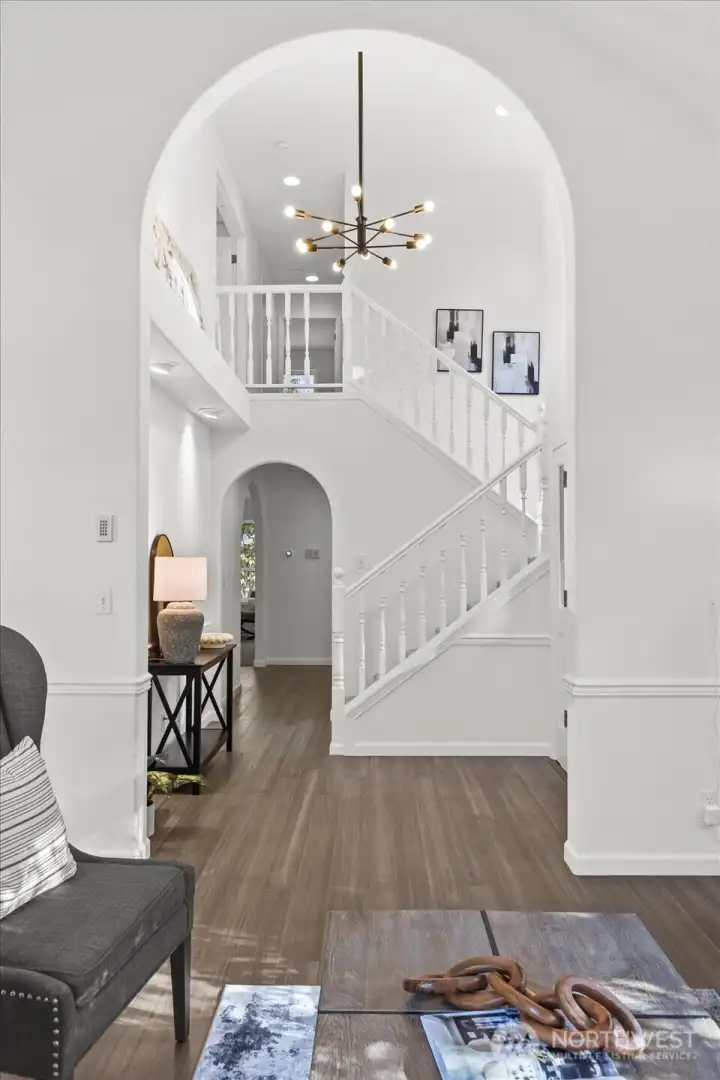Grand two-story entry with an elegant new chandelier and arched doorway sets the stage for this freshly updated home.
