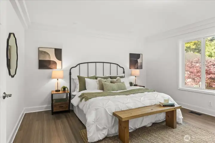 Primary Suite - A peaceful retreat with generous proportions, solid bamboo flooring, large windows overlooking your beautiful yard, and all-new paint and fixtures.