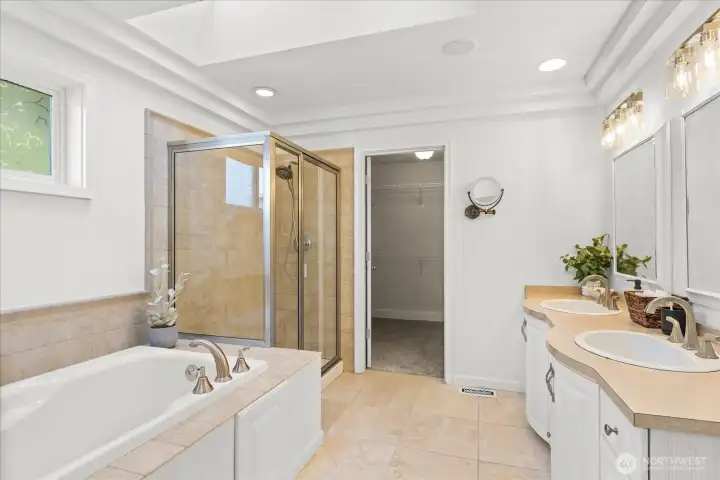 The ensuite features a five-piece layout with soaking tub, walk-in shower, dual vanities, and a spacious walk-in closet.