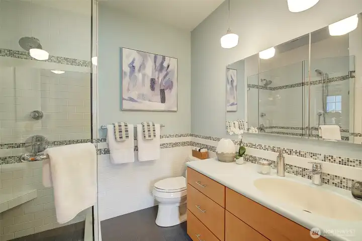 Newly remodeled primary bath with heated floors, lovely glass shower and tile accents.