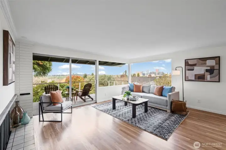 Bright, open-concept living area showcasing panoramic windows, abundant natural light, and direct access to the outdoor seating area. Perfect for relaxing or hosting while enjoying peaceful surrounding views.