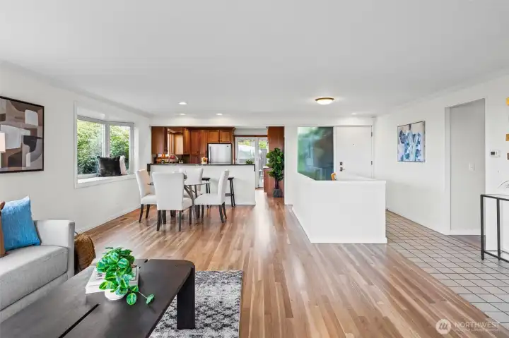 Spacious open layout connects living, dining, and kitchen areas, ideal for modern living and effortless entertaining. Rich wood cabinetry and updated finishes complement the warmth of the hardwood floors throughout.