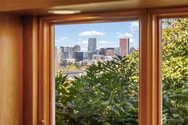 Framed by the kitchen window, enjoy serene greenery in the foreground with stunning Bellevue skyline views beyond—bringing natural beauty and cityscape together in one picturesque outlook.