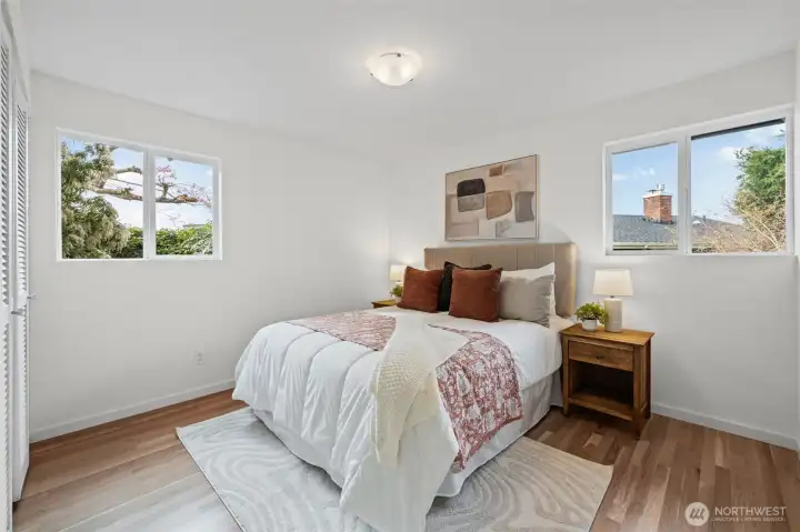 Bedroom Two feaures dual windows bringing in natural light and views of surrounding greenery. Hardwood floors and a closet with professional organizer system add both function and style.