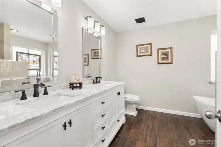 Feel like you are in a spa from your primary bathroom complete with rich wood floors and double sinks