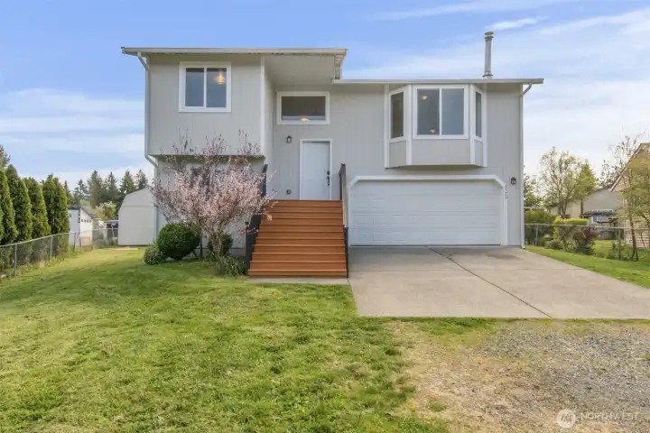 Front of home with new exterior paint on the home and stairs. Driveway was just pressure washed.