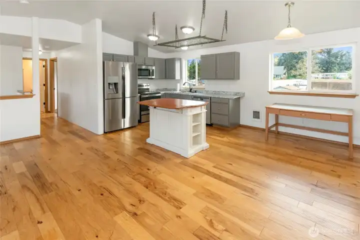 View from living room of kitchen with island and updated counters and a dining room area