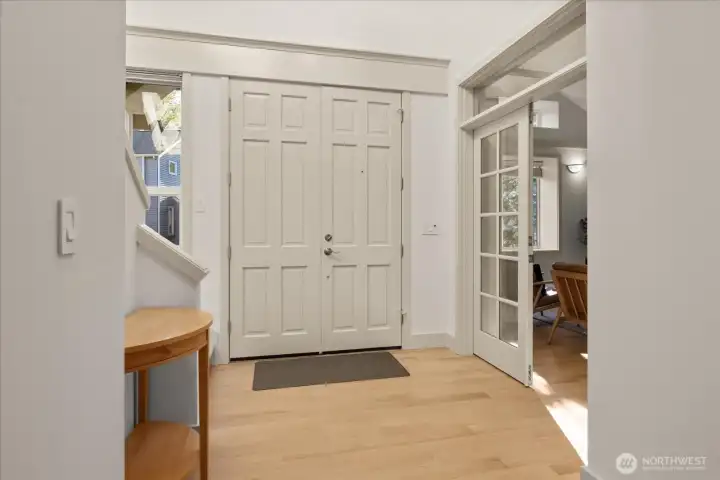 Bright, spacious foyer featuring new rift-and quarter-sawn oak floors (2026), updated lighting, and a clean, modern aesthetic throughout.