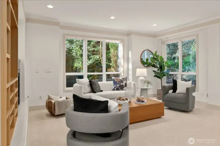 Light-filled living area with large windows framing peaceful, private greenery and a serene natural backdrop.