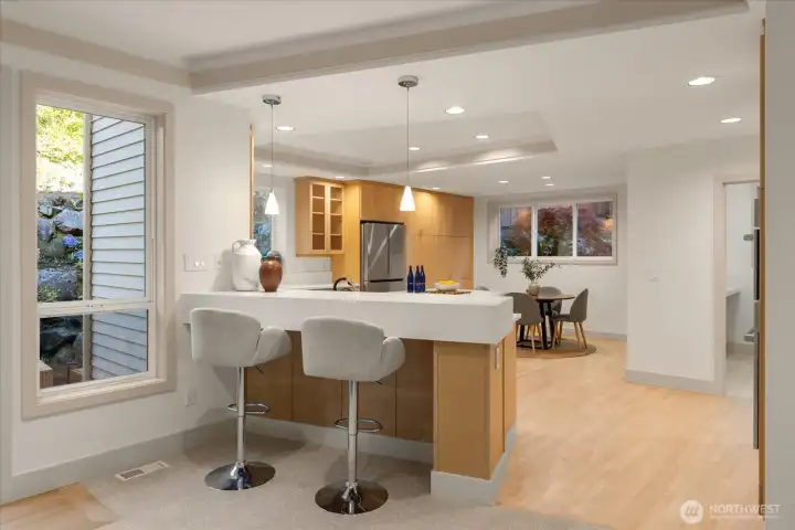 Spacious kitchen peninsula with bar seating, new quartz countertops (2026), refinished hardwood floors, and updated LED lighting throughout.