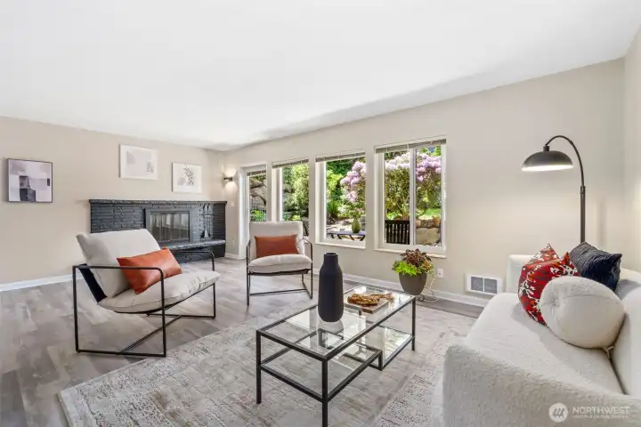Spacious and bright living room with large windows to the garden and wood burning fireplace.