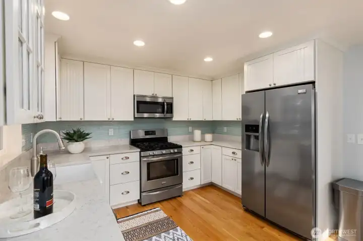 Charming kitchen offers white cabinetry, stainless steel appliances, and a soft, appealing color palette. Charming kitchen offers white cabinetry, stainless steel appliances, and a soft, appealing color palette.
